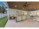 Outdoor kitchen featuring a sink, bar seating, a fan, and a ping pong table for entertainment at 108 Magnolia Ave, Anna Maria, FL 34216