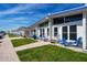 Exterior view of condos featuring a walkway leading to units with patio furniture and blue accents at 1129 Seaside Dr # 15, Sarasota, FL 34242