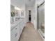 Elegant bathroom featuring double vanity, tiled floor, walk-in shower, and access to a walk-in closet at 11531 Moonsail Dr, Parrish, FL 34219