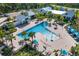A large community pool surrounded by palm trees with many chairs and tables for lounging at 11531 Moonsail Dr, Parrish, FL 34219