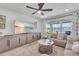 Stylish living room with ceiling fan, comfortable seating, large windows, and water view at 11531 Moonsail Dr, Parrish, FL 34219