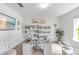 Bright office features a glass desk, bookshelves, and a comfortable chair at 11531 Moonsail Dr, Parrish, FL 34219