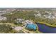 An aerial view of a community with tennis courts and a clubhouse overlooking a pond at 11981 Hunters Creek Rd, Venice, FL 34293