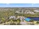Aerial view of the community, showcasing a clubhouse, pool, tennis courts, and natural surroundings at 11981 Hunters Creek Rd, Venice, FL 34293