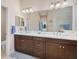 Bright bathroom featuring a double vanity, quartz counters, and a glass shower enclosure at 11981 Hunters Creek Rd, Venice, FL 34293