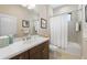 Well-lit bathroom with a tub-shower combination, dark cabinets and neutral finishes at 11981 Hunters Creek Rd, Venice, FL 34293