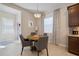 Bright breakfast nook with a round table, comfortable chairs, and a window with patterned drapes at 11981 Hunters Creek Rd, Venice, FL 34293