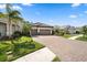 Beautiful home exterior with a paved driveway, a three car garage and manicured landscaping at 11981 Hunters Creek Rd, Venice, FL 34293