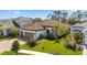 Beautiful home showcasing lush green lawn, a paver driveway, and vibrant, well-maintained landscaping at 11981 Hunters Creek Rd, Venice, FL 34293