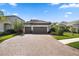 Beautiful home exterior with a paved driveway, a three car garage and manicured landscaping at 11981 Hunters Creek Rd, Venice, FL 34293