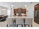 Bright kitchen with a granite island, seating, stainless appliances, and dark cabinets at 11981 Hunters Creek Rd, Venice, FL 34293
