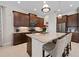 Kitchen featuring granite island, stainless steel appliances, and dark wood cabinetry at 11981 Hunters Creek Rd, Venice, FL 34293