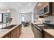 Modern kitchen with granite countertops, stainless steel appliances, breakfast nook, and dark brown cabinetry at 11981 Hunters Creek Rd, Venice, FL 34293