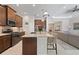 Open-concept kitchen featuring a granite island with seating, stainless appliances, and dark cabinets at 11981 Hunters Creek Rd, Venice, FL 34293