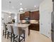 Kitchen featuring an island with granite countertops, modern appliances, and dark wood cabinetry at 11981 Hunters Creek Rd, Venice, FL 34293