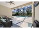 Screened-in pool area with ceiling fan, furniture, and view of the trees at 11981 Hunters Creek Rd, Venice, FL 34293