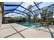 Enclosed pool area with clear blue water, spa and landscaping at 11981 Hunters Creek Rd, Venice, FL 34293