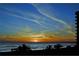 Stunning sunset view over the ocean, silhouetting palm trees, and creating a serene and peaceful ambiance at 1211 Gulf Of Mexico Dr # 207, Longboat Key, FL 34228