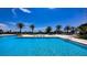 A luxurious outdoor pool is surrounded by lush landscaping and seating at 1211 Gulf Of Mexico Dr # 207, Longboat Key, FL 34228