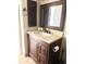 Bathroom vanity with stone countertop, dark wood cabinet, and bronze fixtures at 1250 N Portofino Dr # 408Mar, Sarasota, FL 34242