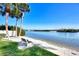 Tranquil beach view featuring a peaceful bench and a serene waterfront, ideal for relaxing outdoors at 1250 N Portofino Dr # 408Mar, Sarasota, FL 34242