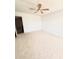 A bedroom with carpet, white walls, a ceiling fan, and a view into the attached bathroom at 1250 N Portofino Dr # 408Mar, Sarasota, FL 34242