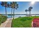 Beautiful community beach area with palms, picnic tables, and serene water views for relaxing outdoors at 1250 N Portofino Dr # 408Mar, Sarasota, FL 34242