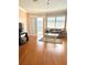Living room featuring hardwood floors, ceiling fan, couch, windows with blinds, TV, and sliding glass doors at 1250 N Portofino Dr # 408Mar, Sarasota, FL 34242