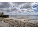 Picturesque beachfront view with calm waters, sandy shore, and scenic cloudy sky at 14459 River Beach Dr # 218, Port Charlotte, FL 33953