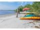 Kayaks on a sandy beach featuring clear water and tropical foliage in a coastal community at 14459 River Beach Dr # 218, Port Charlotte, FL 33953