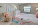 Well-lit bedroom boasts a decorative chair, neutral decor, and a bright window overlooking lush tropical greenery at 14459 River Beach Dr # 218, Port Charlotte, FL 33953