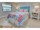 Comfortable bedroom features colorful coral-themed bedding, beach-themed decor, a bright window, and plenty of natural light at 14459 River Beach Dr # 218, Port Charlotte, FL 33953