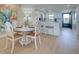 Open concept dining area with a white table and chairs, leading to a modern kitchen at 14459 River Beach Dr # 218, Port Charlotte, FL 33953