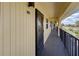 Exterior hallway leading to unit C218 featuring covered walkway and black railings at 14459 River Beach Dr # 218, Port Charlotte, FL 33953