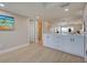 Bright, airy living area with light wood floors and white cabinets, leading to bathroom and open-concept living spaces at 14459 River Beach Dr # 218, Port Charlotte, FL 33953