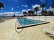 Inviting community pool area with lounge chairs and a white privacy fence at 14459 River Beach Dr # 218, Port Charlotte, FL 33953