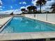Refreshing community pool surrounded by palm trees and a privacy fence at 14459 River Beach Dr # 218, Port Charlotte, FL 33953