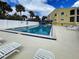 Community pool area offering a relaxing atmosphere, palm trees and lounge chairs at 14459 River Beach Dr # 218, Port Charlotte, FL 33953