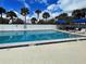 Beautiful community pool with ample lounge seating and lush tropical landscaping at 14459 River Beach Dr # 218, Port Charlotte, FL 33953