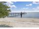 Scenic view of a private beach with a wooden pier extending into the calm water at 14459 River Beach Dr # 218, Port Charlotte, FL 33953