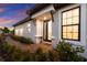 Elegant front entrance with a decorative glass door, lush landscaping, and exterior lighting at 14659 Derna Ter, Lakewood Ranch, FL 34211