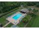 Aerial view of the community pool with chairs, umbrellas, cabana, and lush landscaping at 1709 Curry Trl # 30, Nokomis, FL 34275