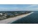 Aerial view of a sandy beach with clear blue water meeting the shoreline and coastal vegetation at 1709 Curry Trl # 30, North Venice, FL 34275