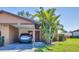 Cozy home with a convenient carport, dark-red front door, and lush palm trees in the front yard at 1709 Curry Trl # 30, Nokomis, FL 34275