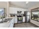 Modern kitchen featuring white cabinets, stainless steel appliances, and tiled flooring at 1709 Curry Trl # 30, Nokomis, FL 34275