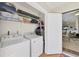 Functional laundry room with washer, dryer, shelving, and access to the living area at 1709 Curry Trl # 30, Nokomis, FL 34275