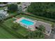 Aerial view of the community pool surrounded by lush landscaping and lounge chairs at 1709 Curry Trl # 30, Nokomis, FL 34275