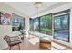 Relaxing sunroom filled with natural light, wicker furniture, and views of lush greenery at 1709 Curry Trl # 30, Nokomis, FL 34275