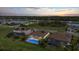 Aerial view of homes with screened in pools and solar panels, as well as sunset views and lush lawns at 17610 Polo Trl, Bradenton, FL 34211