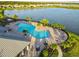 Beautiful aerial view of the community pool and clubhouse, surrounded by lush landscaping and a serene lake at 17610 Polo Trl, Bradenton, FL 34211